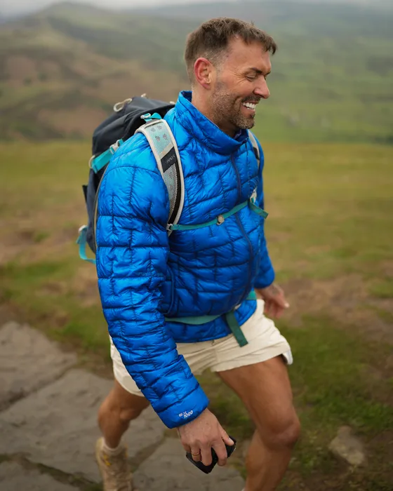 Adrian Davies, smiling, out walking in the hills.